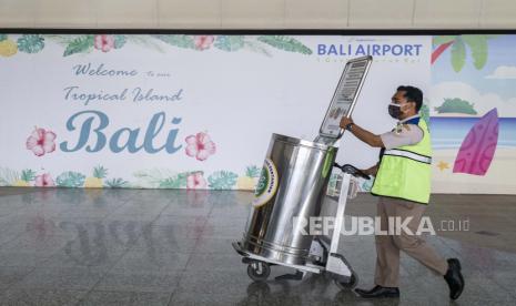 Seorang petugas karantina berjalan di area kedatangan internasional selama pembukaan bandara Internasional Ngurah Rai di Bali, Indonesia, 14 Oktober 2021. 