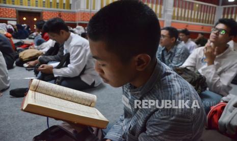 Seorang peserta membaca Alquran sebelum dimulainya pembukaan Sanlat Ramadhan 1445 H yang digelar Baznas Provinsi Jawa Barat dan Disdik Kota Bandung, di Bale Asri Pusdai, Kota Bandung, Jawa Barat, Jumat (15/3/2024). Pesantren kilat yang bertajuk Generasi Emas 2045 yang Cinta Zakat ini diikuti oleh ratusan pelajar tingkat SD hingga SMA. Kegiatan berlangsung dari tanggal 14 hingga 17 Maret 2024.