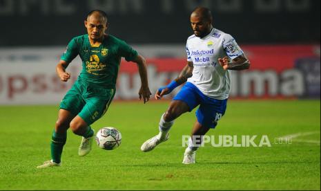 Penyerang Persib Bandung, David Da Silva membayangi bek Persebaya Dandi Maulana pada laga Grup C Piala Presiden di Stadion Gelora Bandung Lautan Api, Bandung, Jumat (17/6/2022). Polisi membeberkan kronologi peristiwa dua orang bobotoh yang meninggal dunia saat pertandingan Persib Bandung melawan Persebaya Surabaya di Stadion GBLA, Kota Bandung berlangsung kemarin, Jumat (17/6/2022). Dua bobotoh berasal dari Bandung dan Bogor.