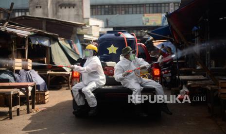 Petugas menyemprotkan cairan disinfektan di area Pasar Cisalak, Depok, Jawa Barat, (ilustrasi). Pemkot Depok meminta masyarakat memanfaatkan pasar online untuk menghindari kerumuman demi mencegah penularan Covid-19.