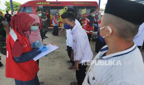 Petugas medis mendata santri saat tiba di Pamekasan, Jawa Timur untuk mencegah penyebaran Covid-19.