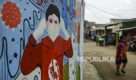 Seorang anak melintas di dekat tembok yang dihiasi mural saat pemberlakuan Pembatasan Sosial Berskala Besar (PSBB) di Depok, Jawa Barat, Rabu (15/4). Mural bertemakan virus Corona (Covid-19) itu menyosialisasikan kepada masyarakat untuk tetap di rumah sebagai upaya untuk memutus rantai penyebaran virus Corona