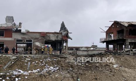 Pekerja darurat membersihkan puing-puing setelah serangan udara menghantam toko ban di kota barat Lviv, Ukraina, Senin 18 April 2022.