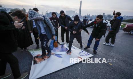 Warga Suriah menginjak foto Presiden Suriah Bashar Assad saat merayakan kedatangan pejuang oposisi di Damaskus, Suriah, Ahad (8/12/2024). Kekuasaan Partai Baath di Suriah tumbang pada Ahad (8/12/2024). Hal itu ditandai ibu kota Damaskus lepas dari kendali rezim Presiden Bashar al-Assad. Runtuhnya kekuatan pasukan Assad di ibu kota mengakhiri 61 tahun pemerintahan Partai Baath yang penuh kekerasan dan 53 tahun kekuasaan keluarga Assad. 