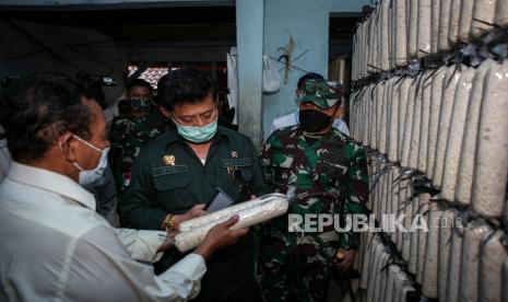 Menteri Pertanian Syahrul Yasin Limpo (tengah) meninjau tempat produksi tempe saat operasi stabilitas harga kedelai di Semanan, Jakarta, Kamis (7/1/2021). Dalam operasi pasar tersebut, kedelai dijual ke perajin seharga Rp8.500 per kilogram dan diupayakan bertahan selama 100 hari ke depan untuk menekan harga kedelai di pasaran yang saat ini mengalami kenaikan. 