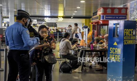 Petugas memeriksa surat keterangan tes Covid-19 ke calon penumpang pesawat terbang sebelum memasuki area Bandara Husein Sastranegara, Kota Bandung, Selasa (26/10). Pemerintah kembali mengubah aturan perjalanan bagi penumpang moda transportasi udara di wilayah Jawa dan Bali. 