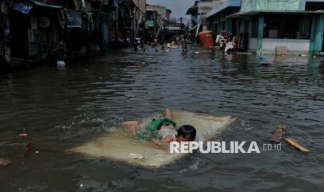 Anak bermain saat banjir rob di kawasan Muara Angke, Jakarta Utara, Selasa (19/11/2024). Banjir rob di sejumlah wilayah di Jakarta Utara kembali terjadi pada Senin (16/12/2024) ini.