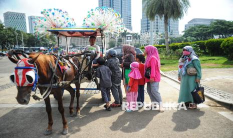 Wisatawan melakukan penawaran harga untuk berkeliling dengan delman di area luar Monumen Nasional (Monas) di Jakarta, Sabtu (28/12/2024). Momen libur sekolah dan nataru seperti ini menjadi berkah tersendiri bagi para kusir delman wisata di Monas.