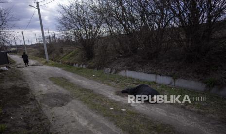 Mayat seorang pria tergeletak di pinggir jalan di Bucha, di pinggiran Kyiv, Ukraina, Senin, 4 April 2022. 