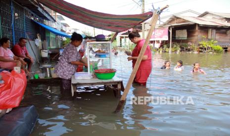 Pedagang melayani pembeli saat banjir rob di Medan Utara, Medan, Sumatera Utara, Kamis (19/9/2024). 