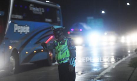 Polisi mengatur kendaraan yang melintas menuju Gerbang Tol Cikampek Utama 1 di Karawang, Jawa Barat.