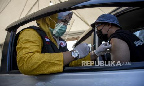 Vaksinator menyuntikan vaksin Covid-19 kepada pengemudi ojek daring secara drive thru atau layanan tanpa turun di Sport Jabar Arcamanik, Jalan Pacuan Kuda, Kota Bandung, Rabu (17/3). 