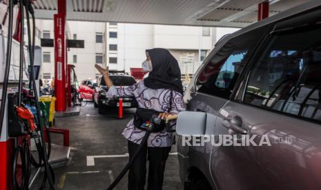 Petugas Stasiun Pengisian Bahan Bakar Umum (SPBU) mengenakan pakaian batik saat melayani pelanggan di SPBU COCO MT Haryono, Jakarta, Senin (2/10/2023). 