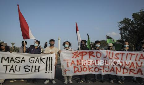 Massa aksi membentangkan spanduk saat menggelar unjuk rasa di Taman Aspirasi, Monas, Jakarta Pusat, Jumat (24/7/2020). Dalam aksi tersebut mereka meminta Presiden untuk membentuk tim pencari fakta independen dalam pengungkapan kasus Djoko Tjandra. 