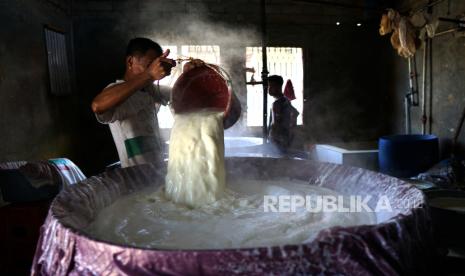 Seorang pekerja menuangkan campuran kedelai sebelum disaring di pabrik tahu di Kota Timur, Kota Gorontalo, Gorontalo, Selasa (12/1/2021). Meski terdapat kenaikan harga kedelai impor dari Rp7.300 per kg menjadi Rp9.800 per kg, produsen tahu setempat memilik tetap menjaga harga Rp40 ribu per papan karena tidak ingin memberatkan dan ditinggal konsumen saat masa pandemi. 