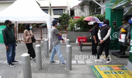 Pengunjung antre untuk pengecekan suhu tubuh di jalur pedestrian Malioboro, Yogyakarta, Jumat (25/12). Pemprov DIY kembali memperpanjang masa tanggap darurat Covid-19 hingga 31 Januari 2021. Perpanjangan masa tanggap darurat Covid-19 ini merupakan yang ke-8 selama masa pandemi. Sementara jumlah pasien Covid-19 di Yogyakarta sudah melebihi 10 ribu orang.