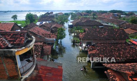 Warga melintasi jalan yang terendam banjir di Desa Karangrowo, Undaan, Kudus, Jawa Tengah, Selasa (28/2/2023). Menurut data BPBD setempat, hujan dengan intensitas tinggi sejak dua pekan terakhir mengakibatkan sebanyak 541 rumah dan 2.159 hektare sawah tergenang serta berdampak pada 4.014 KK di tujuh desa di Kecamatan Jati, Mejobo dan Undaan.  