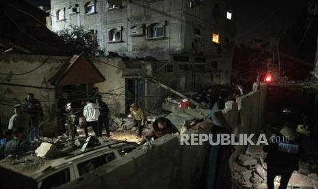 Orang-orang memeriksa puing-puing bangunan tempat tinggal yang dihancurkan oleh tentara Israel, di kamp pengungsi Rafah, Jalur Gaza selatan, 9 Februari 2024.