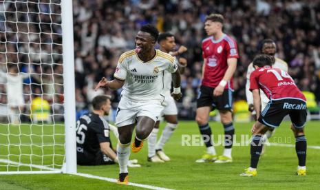 Vinicius Junior dari Real Madrid melakukan selebrasi setelah mencetak gol pertama timnya pada pertandingan sepak bola La Liga Spanyol antara Real Madrid dan Celta Vigo di stadion Santiago Bernabeu di Madrid, Spanyol, Senin (11/3/2024) dini hari WIB. 