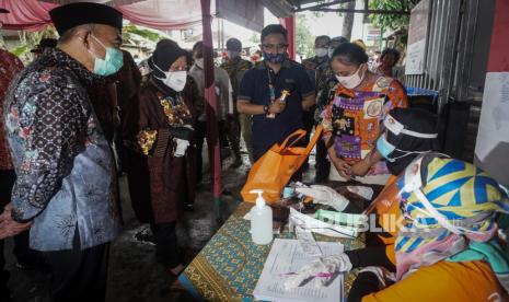 Menteri Koordinator Bidang Pembangunan Manusia dan Kebudayaan (Menko PMK) Muhadjir Effendy (kiri) bersama Menteri Sosial Tri Rismaharini (kedua kiri) meninjau proses penyaluran Bantuan Pangan Non Tunai (BPNT) sembako e-Warung KUbe di Kampung Gulon, Jebres, Solo, Jawa Tengah, Jumat (29/1/2021). Dalam kunjungannya ke Solo,  Menko PMK bersama Mensos meninjau sejumlah penyaluran bantuan sosial tunai dan mengunjungi Balai Besar Rehabilitasi Sosial Penyandang Disabilitas Fisik (BBRSPDF) Prof. Soeharso. 