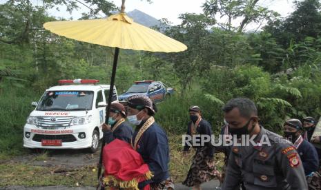 Abdi dalem Keraton Yogyakarta membawa uba rampe menuju Bangsal Srimanganti saat prosesi Labuhan Merapi di Sleman, DI Yogyakarta, Senin (15/3/2021). Upacara Labuhan Merapi merupakan rangkaian Tinggalan Dalem Jumenengan atau bertahtanya Sri Sultan HB X sebagai Raja Keraton Yogyakarta itu digelar secara terbatas karena status Siaga Merapi dan pandemi COVID-19. 