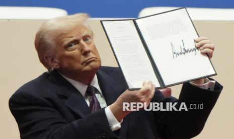 Presiden Donald Trump memegang perintah eksekutif setelah menandatanganinya pada acara parade Pelantikan Presiden di Washington, Senin (20/1/2025) waktu setempat.