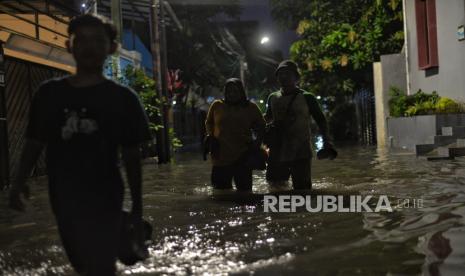 Warga berjalan melintasi area yang terendam banjir di kawasan Pela Mampang, Jakarta Selatan, Rabu (4/1/2023). Banjir tersebut mencapai ketinggian 60 centimeter akibat intensitas hujan yang lebat yang menyebabkan Kali Mampang meluap. Sementara, menurut data Badan Penanggulangan Bencana Daerah (BPBD) DKI Jakarta, banjir terjadi di 28 RT dan 3 ruas jalan di Ibu Kota dengan ketinggian maksimal sekitar 100 centimeter. Republika/Thoudy Badai