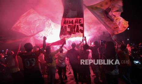 Suporter Persija menyalakan flare saat merayakan kemenangan Persija Jakarta pada laga final Piala Menpora 2021 di Bundaran Hotel Indonesia, Jakarta, Senin (26/4/2021). Suporter Persija The Jakmania berkonvoi memadati Bundaran HI merayakan kemenangan Persija Jakarta menjadi juara Piala Menpora 2021 usai mengalahkan Persib Bandung di Stadion Manahan Solo dengan agregrat 4-1. 