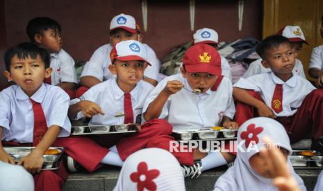 Para siswa menyantap hidangan Makan Bergizi Gratis (MBG) di SDN 05 Sukatani, Depok, Jawa Barat, Senin (6/1/2025). Pada hari pertama program makan bergizi gratis (MBG) tersebut para siswa terlihat antusias menikmati menu makanan. Total sebanyak 406 para siswa kelas 1 hingga kelas 6 menikmati paket menu makanan uang teridiri dari Nasi, Daging Ayam, Tempe, Sayur Buncis dan Buah Jeruk. Salah satu siswa kelas 5 Fatah Ar Rozak mengaku senang mendapatkan makan bergizi gratis dari program pemerintah tersebut. Menurutnya rasa makanannya enak dan untuk porsi makanannya cukup mengenyangkan.