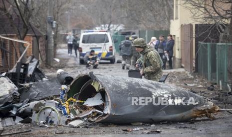  Seorang prajurit Angkatan Darat Ukraina memeriksa pecahan pesawat yang jatuh di Kyiv, Ukraina, Jumat, 25 Februari 2022. Tidak jelas pesawat apa yang jatuh dan apa yang menjatuhkannya di tengah invasi Rusia di Ukraina. Rusia menekan invasi ke Ukraina ke pinggiran ibukota setelah melancarkan serangan udara di kota-kota dan pangkalan militer dan mengirimkan pasukan dan tank dari tiga sisi.