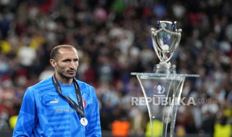 Pemain Italia Giorgio Chiellini berjalan melewati trofi pada akhir pertandingan sepak bola Finalissima antara Italia dan Argentina di Stadion Wembley di London, Kamis (2/6/2022) dini hari WIB.