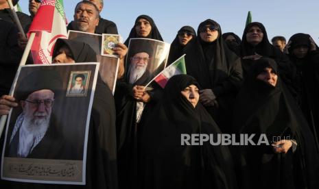 Demonstran pro-pemerintah Iran memegang poster Pemimpin Tertinggi Ayatollah Ali Khamenei selama rapat umum mereka mengutuk protes anti-pemerintah baru-baru ini atas kematian Mahsa Amini, seorang wanita berusia 22 tahun yang telah ditahan oleh polisi moral negara, di Teheran, Iran, Minggu, 25 September 2022. Dewan Pengawas Facebook Tinjau Konten Protes Iran Dorong Kekerasan