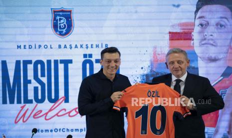 Transfer baru Basaksehir mantan pemain internasional Jerman Mesut Oezil (kiri) dan presiden klub Goksel Gumusdag (kanan) selama upacara penandatanganan di Istanbul, Turki, 14 Juli 2022. Oezil menandatangani kontrak satu tahun dengan Basaksehir dengan opsi perpanjangan untuk tahun kedua.