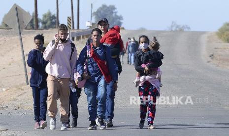  Seorang pria muda berbicara di ponsel saat ia dan sekelompok migran yang memasuki Amerika Serikat dengan menyeberangi Sungai Colorado dari Meksiko dekat County 13th Street di Lembah Yuma Arizona, berjalan ke timur di County 14th Street di Lembah Yuma Arizona Senin pagi, 12 Desember. 6, 2021. Sopir truk pengangkut puluhan migran yang tewas diduga mengonsumsi metamfetamin. Ilustrasi.