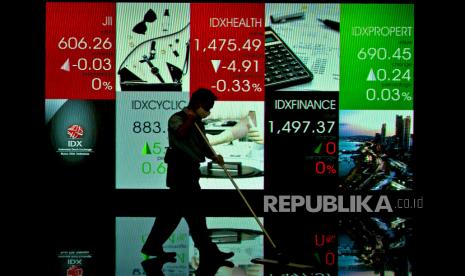 Pekerja membersihkan lantai di dekat layar pergerakan Indeks Harga Saham Gabungan (IHSG) di gedung Bursa Efek Indonesia, Jakarta, Jumat (18/11/2022). 