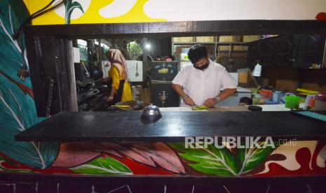 Pelaku usaha kuliner, Adityo Nugraha (25), memasak makanan pesanan konsumen, di kafenya di Padang, Sumatera Barat, Selasa (25/5/2021).  Adityo yang merupakan nasabah PT Pegadaian (Persero) memanfaatkan pinjaman kredit ultramikro untuk membantu melanjutkan bisnis kafernya yang sepi sejak pandemi