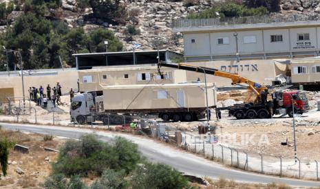  Pihak berwenang Israel, mengevakuasi pemukim dan memindahkan rumah dengan derek karena mereka diduga dibangun secara ilegal di pos terdepan Beit Dror di selatan kota Hebron di Tepi Barat pada 27 Juli 2021. Hebron adalah rumah bagi sekitar 160 ribu Muslim Palestina. Ilustrasi.