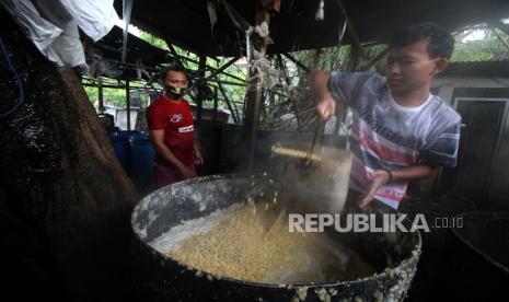 Perajin tempe mengangkat kedelai rebus di tempat produksi (ilustrasi).