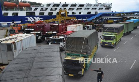 Petugas memandu antrean truk yang akan menyeberang ke Sumatera di Dermaga V Pelabuhan Merak, Banten, Selasa (27/10/2020). Menurut data kantor PT ASDP Cabang Merak menjelang libur panjang terjadi peningkatan arus penyeberangan dari Jawa ke Sumatera dan sebaliknya sebesar 6-10 persen dibanding hari biasa. 