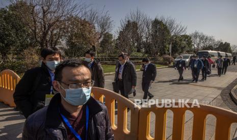 Pejabat China meninggalkan ruang konferensi di hotel Hilton tempat para anggota Organisasi Kesehatan Dunia (WHO) menginap, di Wuhan, China, 29 Januari 2021. Tim pakar internasional dari Organisasi Kesehatan Dunia (WHO) mengakhiri karantina selama 14 hari mereka. pada 28 Januari dan pindah ke hotel Hilton di Wuhan. Mereka akan mulai menyelidiki asal mula COVID-19 selama beberapa minggu ke depan.