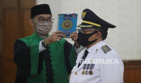 Rohaniawan mengambil sumpah Wali Kota Blitar Santoso (kanan) saat pelantikan di Gedung Negara Grahadi, Surabaya, Jawa Timur, Selasa (19/5/2020). Santoso pada Senin pagi menjadi korban perampokan.