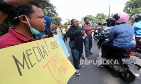 Sejumlah wartawan membawa poster dan membagikan cairan antiseptik pembersih tangan kepada warga di Kota Kediri, Jawa Timur, Rabu (18/3/2020). Aksi pembagian antiseptik dan sharing tentang reportase wabah virus secara aman tersebut bertujuan memberikan wawasan kepada wartawan agar mampu menghasilkan berita yang bermutu sehingga tidak terjadi kepanikan di masyarakat terkait COVID-19.(Antara/Prasetia Fauzani)