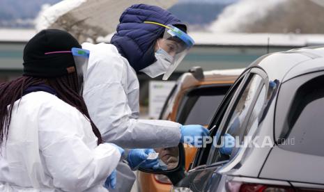  Spesialis pengujian COVID-19 Alex Honn, kanan, dan Tokeya Berry menguji seorang pengemudi di lokasi pengujian virus corona drive-up Selasa, 21 Desember 2021, di Bellingham, Wash. Pejabat kesehatan Washington mengatakan Selasa setidaknya 400 kasus COVID baru Varian -19 telah dikonfirmasi, tetapi omicron itu belum menyusul kasus delta di negara bagian itu. Selama dua minggu terakhir, negara bagian Washington rata-rata memiliki lebih dari 1.500 kasus baru, kemungkinan kasus COVID-19 sehari.