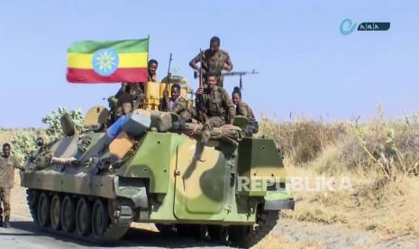  Gambar ini dibuat dari video tak bertanggal yang dirilis oleh Kantor Berita Ethiopia milik negara pada Senin, 16 November 2020 menunjukkan militer Ethiopia duduk di sebuah pengangkut personel lapis baja di sebelah bendera nasional, di jalan di daerah dekat perbatasan Tigray dan wilayah Amhara di Ethiopia. Memanasnya konflik di Ethiopia membuat AS jatuhkan sanksi dan melarang perjalanan ke negara itu. 