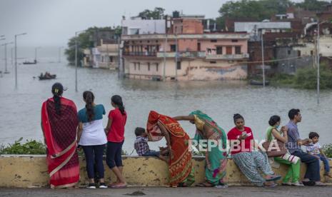  Orang-orang berdiri di tepi sungai Gangga yang meluap di Prayagraj, India, Selasa, 10 Agustus 2021. Ketinggian air Sungai Gangga telah meningkat karena hujan monsun yang terus-menerus.