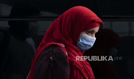 Seorang wanita yang dievakuasi dari Kabul, Afghanistan, berjalan melewati terminal sebelum naik bus setelah mereka tiba di Bandara Internasional Washington Dulles, di Chantilly, Va, pada Senin, 30 Agustus 2021.