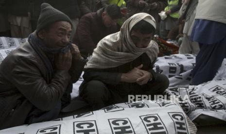  Orang-orang dari komunitas Syiah Hazara berkabung di sekitar mayat pekerja tambang batu bara yang dibunuh oleh pria bersenjata tak dikenal di dekat ladang batu bara Machh, di Quetta, Pakistan, Minggu, 3 Januari 2021.