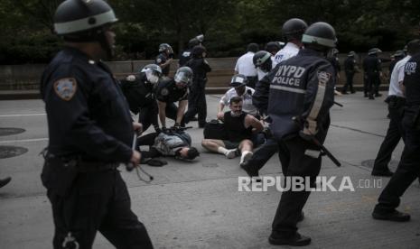 Polisi menangkap pengunjuk rasa yang menolak keluar dari jalan selama jam malam yang diberlakukan saat berbaris dalam unjuk rasa solidaritas yang menyerukan keadilan terkait kematian George Floyd, Selasa, 2 Juni 2020, di New York. Floyd meninggal setelah ditahan oleh petugas kepolisian Minneapolis pada 25 Mei