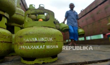 Pekerja menurunkan tabung gas LPG 3 kilogram bersubsidi.