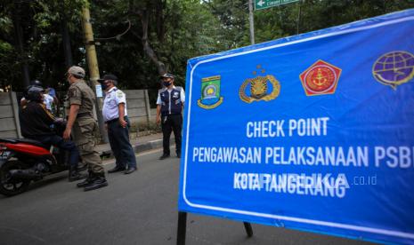 Petugas gabungan memberikan sosialisasi penerapan PSBB kepada pengendara di jalan M.H Thamrin, Cikokol, Kota Tangerang, Banten, Rabu (15/4/2020)